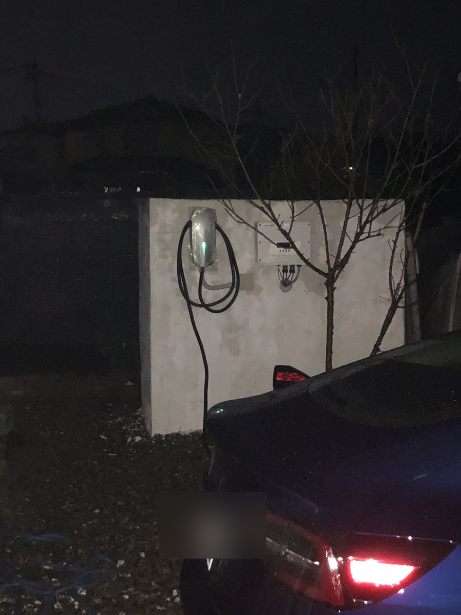 夜間に駐車場で稼働するEV充電器(Wallbox)と車両の位置関係。ナンバープレートはぼかし処理済み